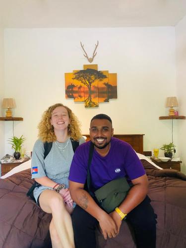 a man and a woman sitting on a bed at The kingdom of ella in Ella