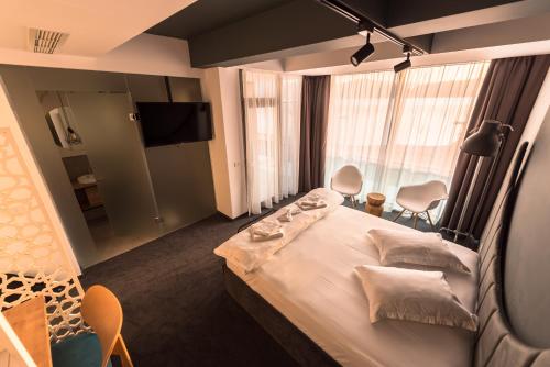 um quarto de hotel com uma cama e uma televisão em Hotel Arka em Orşova