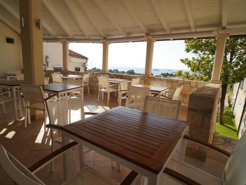 ein Restaurant mit Tischen und Stühlen auf einer Terrasse in der Unterkunft Hotel Vista in Vrsar
