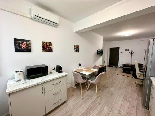 a kitchen and dining room with a table and a room at Angela Nordic apartment. in Suceava