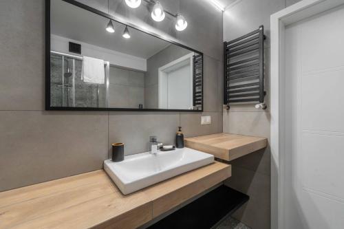 een badkamer met een witte wastafel en een spiegel bij Apartamenty Laguna Beskidów 80 i 81 Przy Jeziorze Żywieckim - Dream Apart in Zarzecze