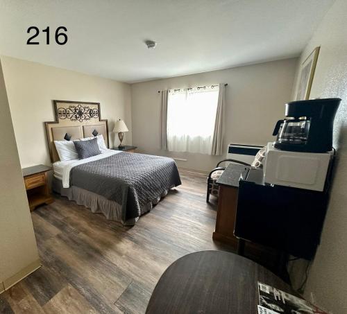 a bedroom with a bed and a desk and a window at Alaska Angler's Inn in Soldotna
