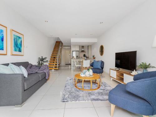 Μια τηλεόραση ή/και κέντρο ψυχαγωγίας στο Beachside Haven Modern Townhouse with Pool