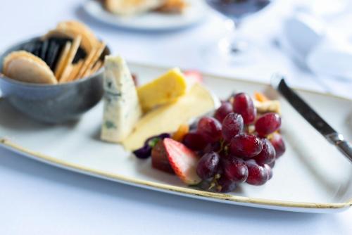 a plate with fruit and cheese and a bowl of crackers at Park Proxi Gibraltar Bowral in Bowral