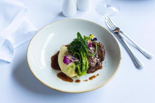 a plate of food with meat and vegetables on a table at Park Proxi Gibraltar Bowral in Bowral