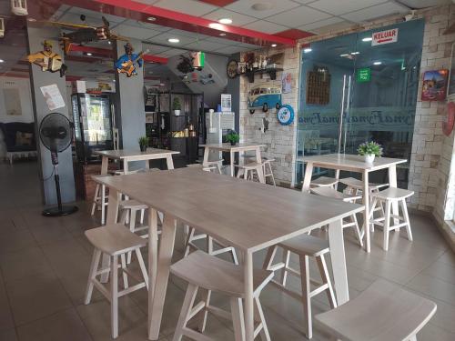 a large wooden table and chairs in a restaurant at Motel Fyna in Kangar