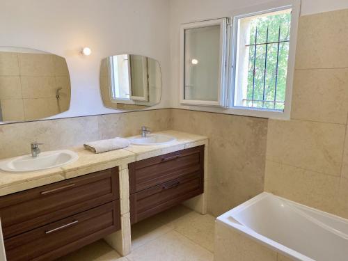 a bathroom with two sinks and a tub and a mirror at Mas provençal in Draguignan