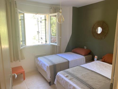 a bedroom with two beds and a window at Mas provençal in Draguignan