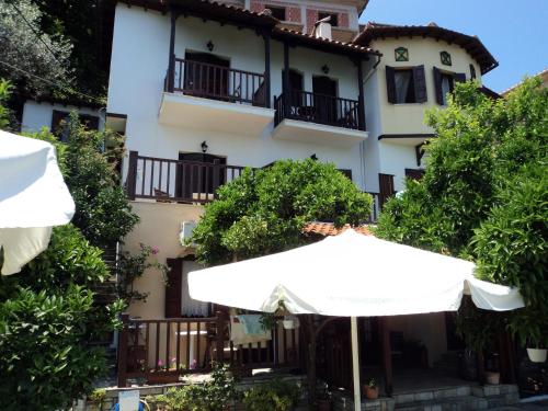 un gran edificio blanco con sombrilla en Villa Sunray, en Agios Ioannis