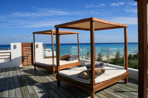 two beds on a deck with a view of the ocean at Casa del Mar by Stella Rentals in Playa del Carmen
