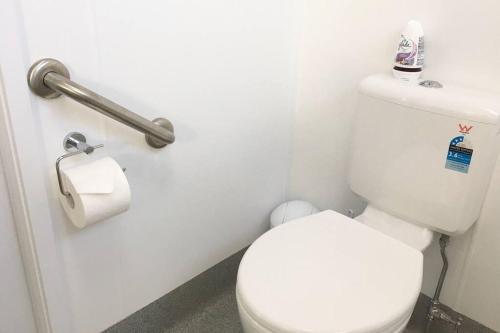 a bathroom with a toilet and a roll of toilet paper at Bribie Getaway in Bongaree
