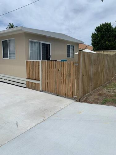 a house with a wooden fence in front of it at Bribie Getaway in Bongaree