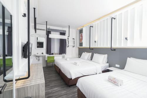 um quarto de hotel com duas camas e uma casa de banho em Istanaku em Manado