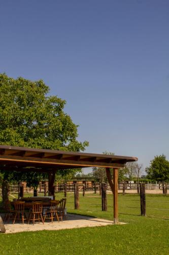 a wooden pavilion with tables and chairs in a park at Ranch borgo bella vita in Cavalier