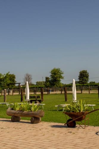 a group of tables with white umbrellas in a park at Ranch borgo bella vita in Cavalier