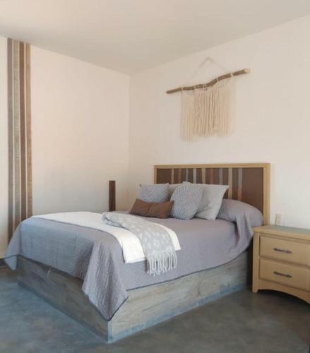 a bedroom with a large bed and a night stand at Tres Velas Surf in Celestino Gasca