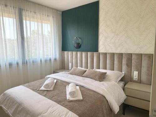 a bedroom with a large bed with two towels on it at Luxury Apartment Aquamarine in Kožino