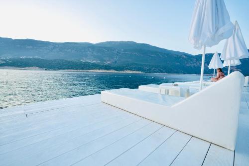 a person sitting on a boat with an umbrella at Club Çapa Hotel in Kas
