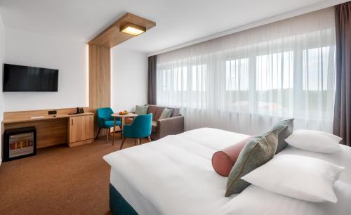 ein Hotelzimmer mit einem Bett und einem TV in der Unterkunft Hunguest Hotel Gyula in Gyula
