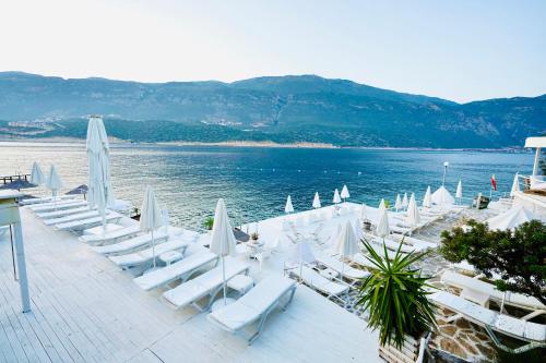 a group of lounge chairs and umbrellas on a beach at Club Çapa Hotel in Kas