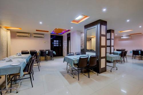un comedor con mesas y sillas en un restaurante en OYO Flagship Hotel Sunraj en Ranchi