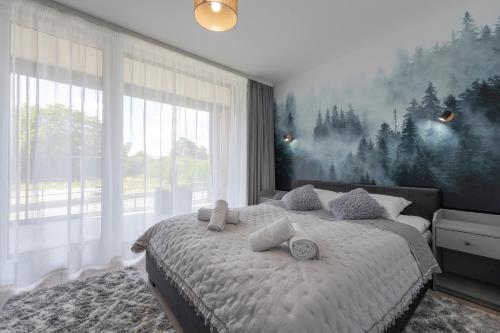 een slaapkamer met een bed met een schilderij aan de muur bij Apartamenty Laguna Beskidów 80 i 81 Przy Jeziorze Żywieckim - Dream Apart in Zarzecze