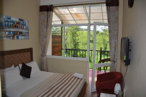 a bedroom with a bed and a balcony with a window at Hill Cool Hotel & Restaurant in Hatton