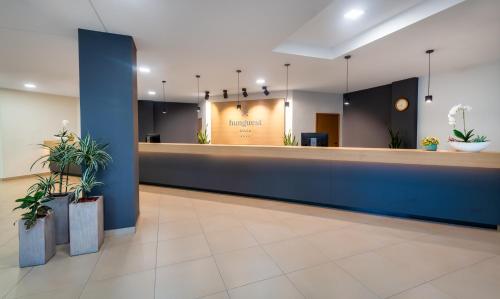 a lobby with a waiting area with plants at Hunguest Hotel Gyula in Gyula