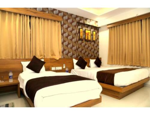 two beds in a hotel room at Hotel Leisure, Ahmedabad in Ahmedabad