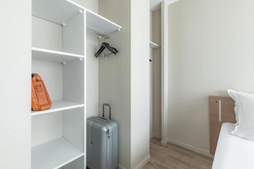 a room with a suitcase and a closet at Appart'City Classic Bordeaux Centre in Bordeaux