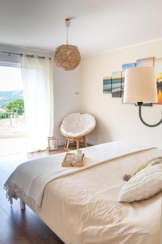 une chambre avec un grand lit et une chaise dans l'établissement Grande villa de standing avec piscine à Sagone en Corse, à Sagone