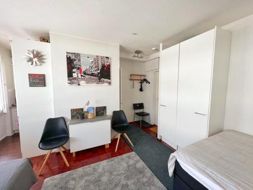 um quarto com uma cama, uma secretária e 2 cadeiras em Sweethome Studio 48 City Center Аlbertinkatu em Helsinque