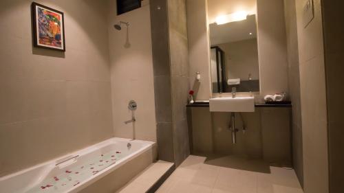 a bathroom with a bath tub and a sink at 7 Apple Resort Lonavala in Lonavala