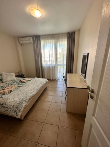 a bedroom with a bed and a desk and a window at Summer Dreams B26 in Sunny Beach