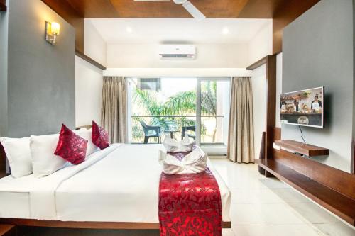 1 dormitorio con 1 cama grande y asiento rojo en 7 Apple Resort Lonavala, en Lonavala