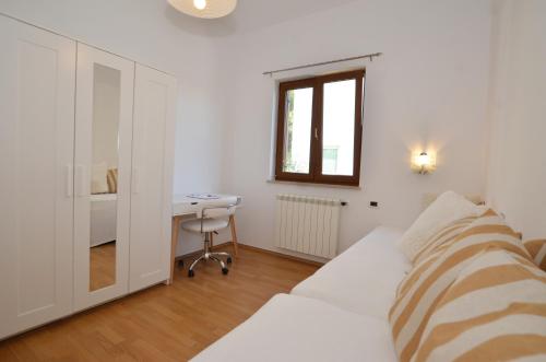 a white room with a bed and a desk at Cocaletto A&B in Rovinj