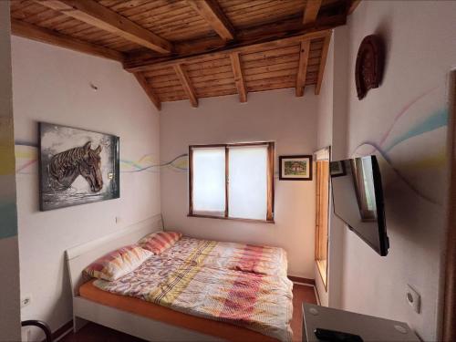 a small bedroom with a bed and a window at Domačija Paternoster in Litija