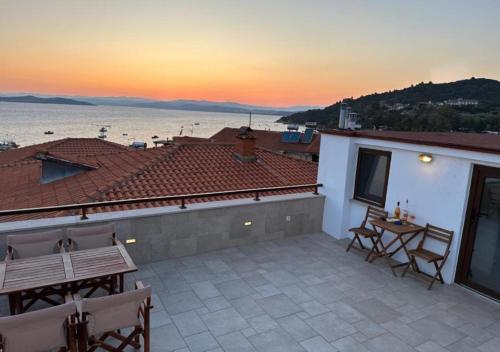 a patio with a table and chairs on a building at Yulia Luxury Apartments in Ouranoupoli