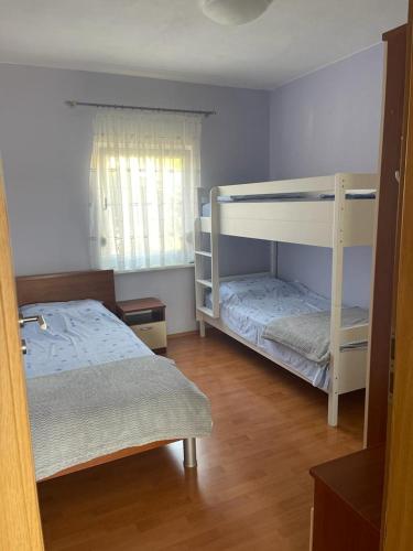 a bedroom with two bunk beds and a window at Apartments Bolont in Pag