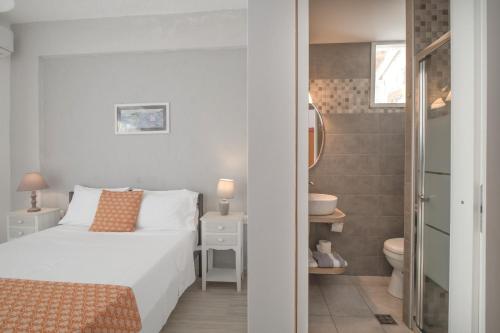 a white bedroom with a bed and a bathroom at Levantes Hotel in Patitiri