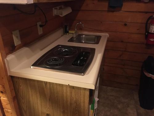 cocina con fogones y fregadero en 2 Cabin for simple people not for picky rental car available, en Custer