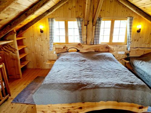 a bedroom with a bed in a log cabin at Experience this unique wooden house! in Seltenheim