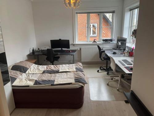 een slaapkamer met een bed en een bureau met 2 computers bij Familievenlig lejlighed tæt på Amager Strand in Kopenhagen