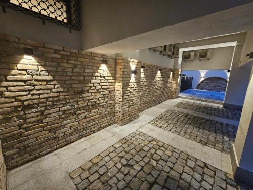 a room with a stone wall and shadows on the wall at Rosetti One in Constanţa