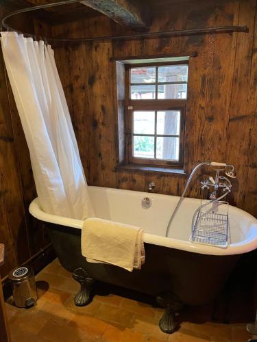 a bath tub in a room with a window at La Ferme de Marie in Rangen