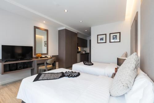 a hotel room with two beds and a television at Kantary Hotel Korat in Nakhon Ratchasima