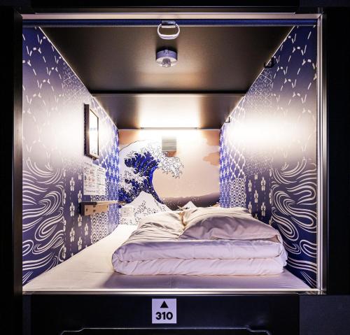 大阪市にあるカプセルホテル NINJA & GEISHAの表示ケースにベッドが備わる部屋