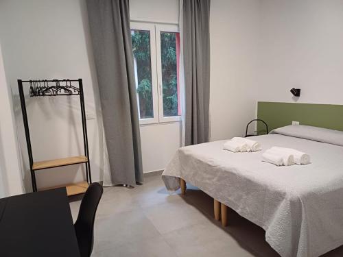 een slaapkamer met 2 bedden en een raam bij B&B NAR in Como