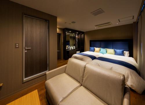 富士吉田的住宿－Hotel Fuji Tatsugaoka，一间卧室配有一张大床和一张沙发
