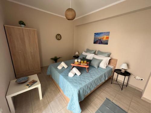 a bedroom with a bed with a tray of food on it at Navagio Luxury Apartment in Epanomi
